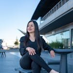 Smiling woman in professional attire relaxing outdoors in Juárez, Mexico.